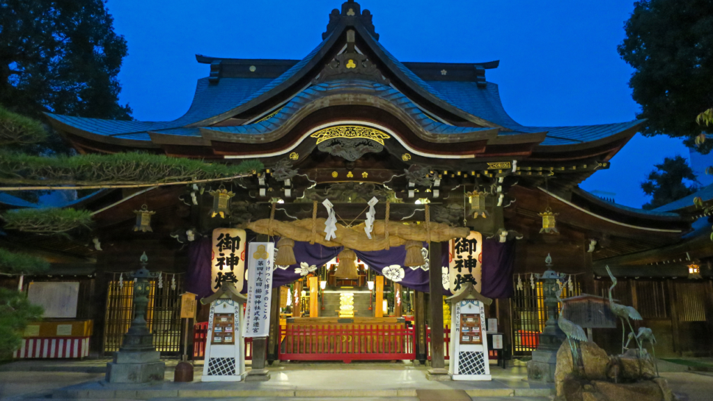 Illuminated main hall of Kushida Shrine at night